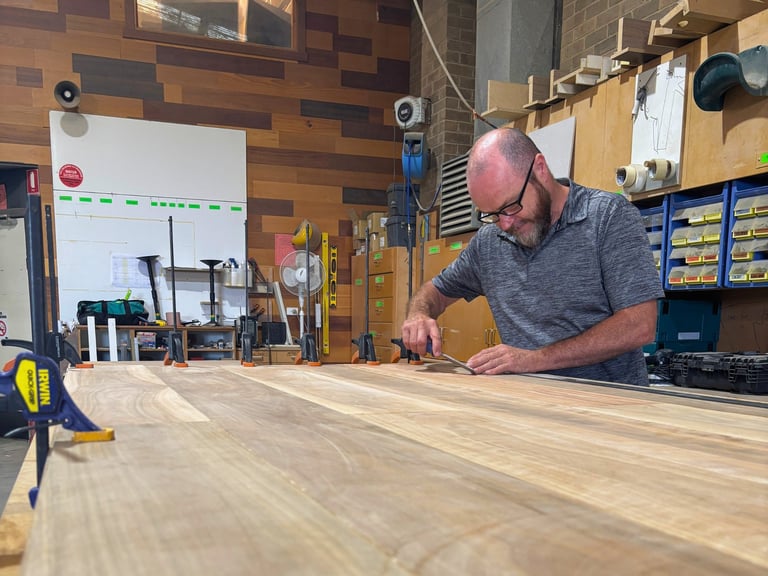 Master craftsman at Individual Design workshop crafting custom joinery with precision tools